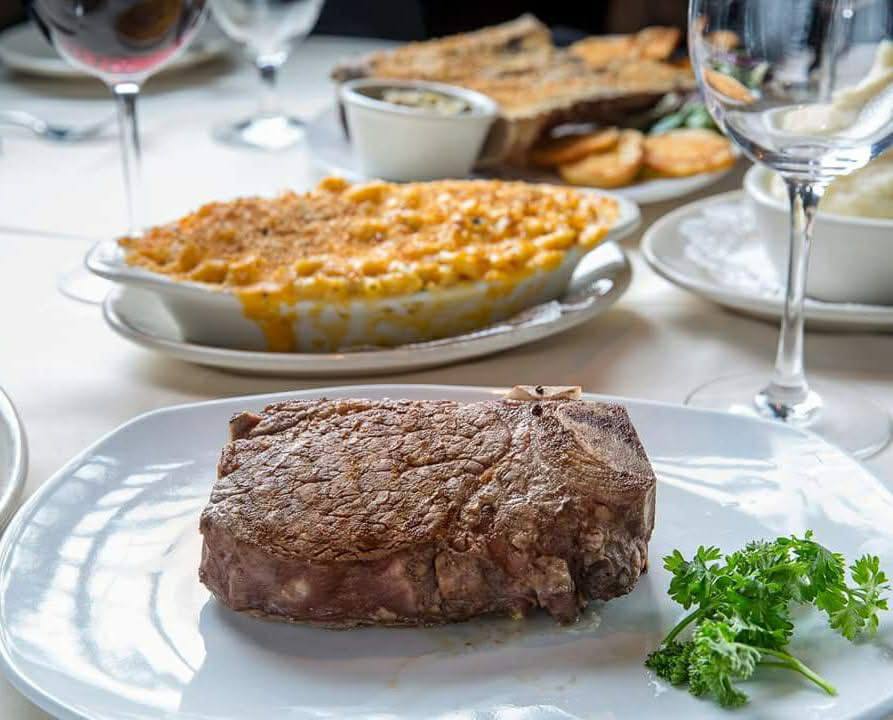 Filet mignon plated with house mac & cheese and bread service